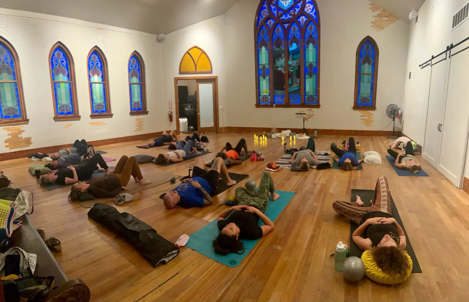 A large restorative class rests on the wood floor of the hall, lit by tall blue stained-glass windows