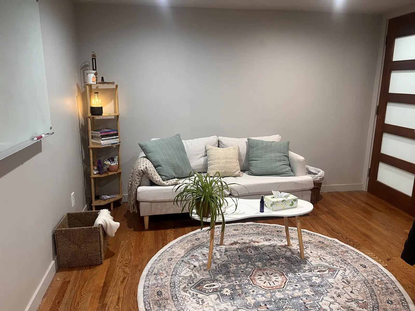 The basement flex studio set up as a quiet session room, with a sofa, round rug, and soft lamplight